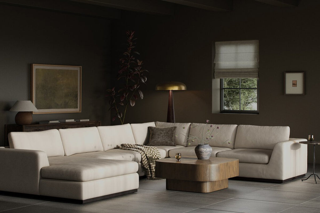Modern living room with a beige sectional sofa, coffee table, and decorative items.