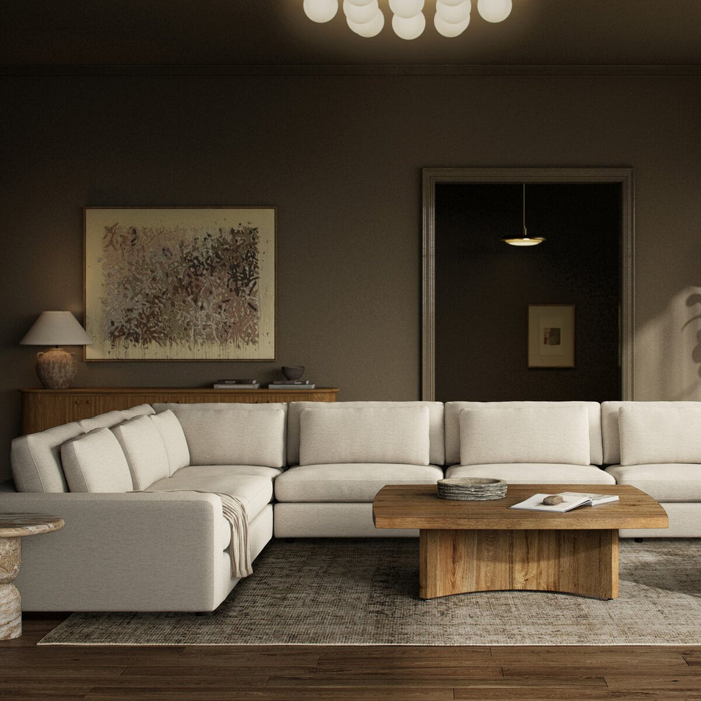 Modern living room with a sectional sofa, wooden coffee table, and abstract art on the wall.