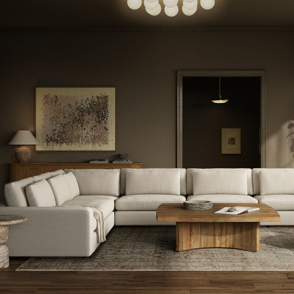 Modern living room with a sectional sofa, wooden coffee table, and abstract art on the wall.
