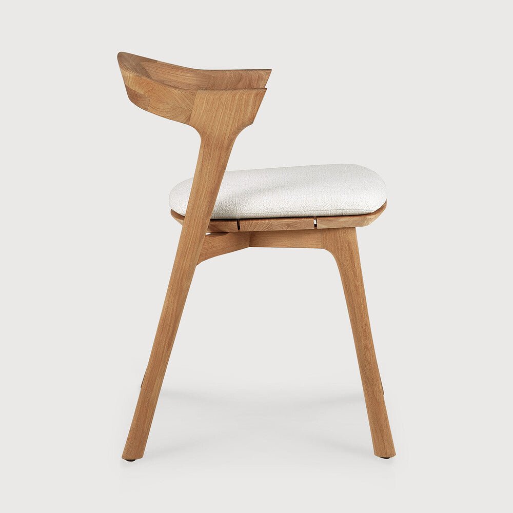 Wooden chair with a white cushion on a light gray background