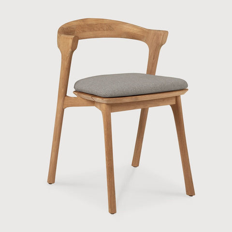 Wooden chair with a white cushion on a light gray background