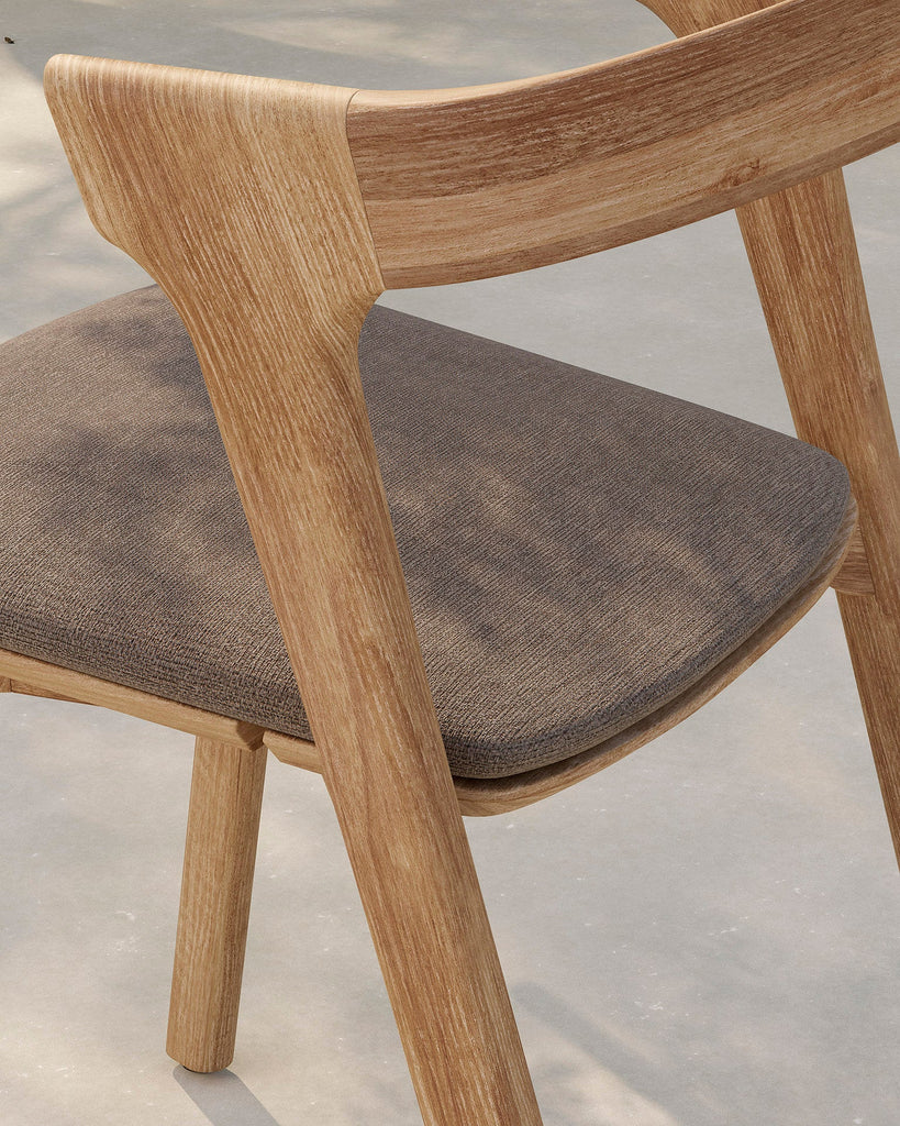Wooden chair with a brown cushion on a light gray background