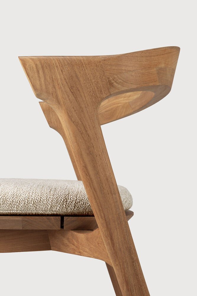 Wooden chair with a textured cushion on a light background