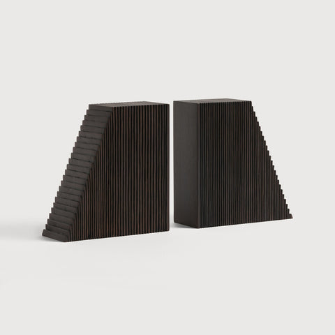 Two black triangular bookends on a light gray background