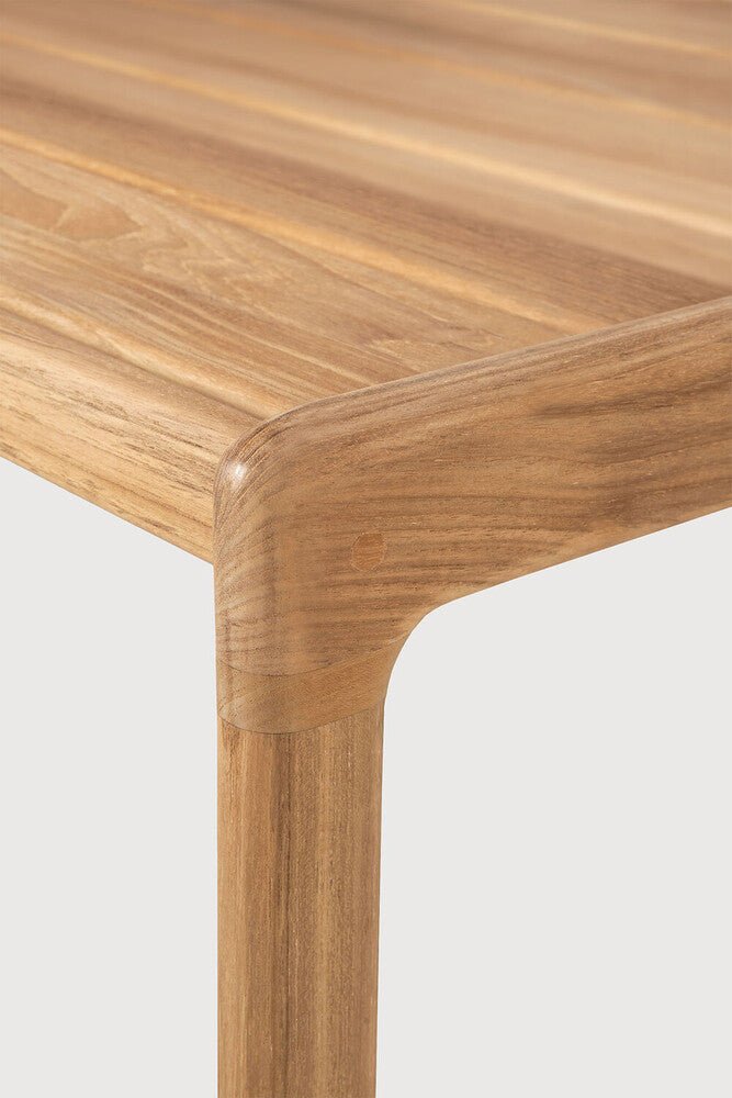 Close-up of a wooden table corner on a light gray background